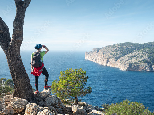 Girl traveler overwatching bay.  Mountain  trail along west shore. photo