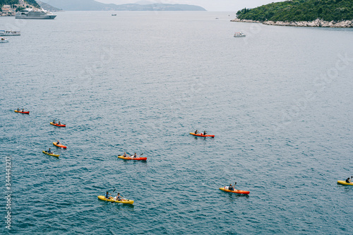 A group of tourists travel in pairs kayaks by sea, near old town of Dubrovnik, Croatia. Concept banner travel. Aerial top view.
