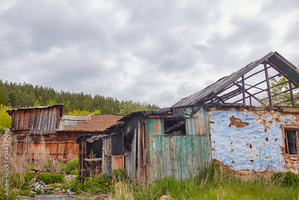 A dilapidated abandoned house in the countryside. There are signs of fire, desolation and old junk A dilapidated abandoned house in the countryside. There are signs of fire, desolation and old junk