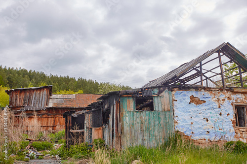 A dilapidated abandoned house in the countryside. There are signs of fire, desolation and old junk © svetlanaz