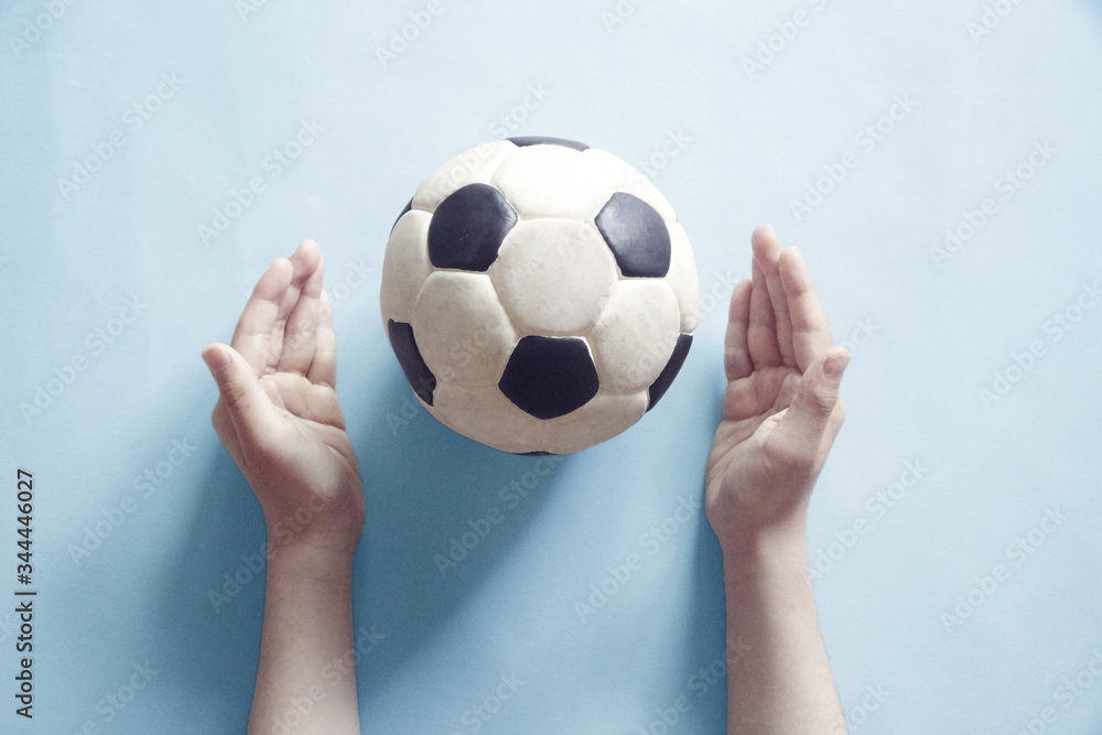 Fototapeta premium 子供の手とサッカーボールとステイホームのメッセージ