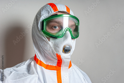 Scientist in protective gear with buttons on a suit on a light background