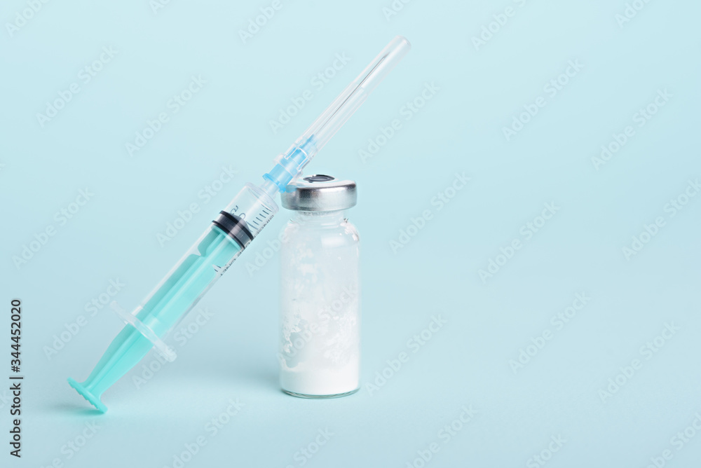 medical syringe, glass ampoule on blue background with copy space, vaccination medical syringe, glass ampoule on blue background with copy space, vaccination
