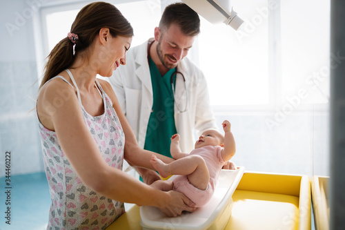 Beautiful mother and baby on medical examination with doctor in hospital photo