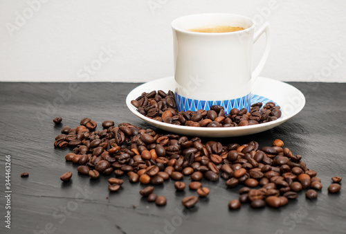 Coffee cup and coffee beans on the black background 