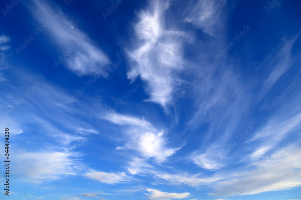 Blue sky landscape background. Picturesque beautiful cirrus clouds create unusual patterns in the sky. Cloudy weather in spring, summer.
