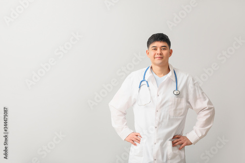 Male Asian doctor on light background