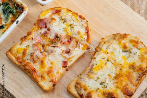 Pizza cheese toasted bread with ham cheese and imitation crab on wooden cutting boards. Isolate on black 