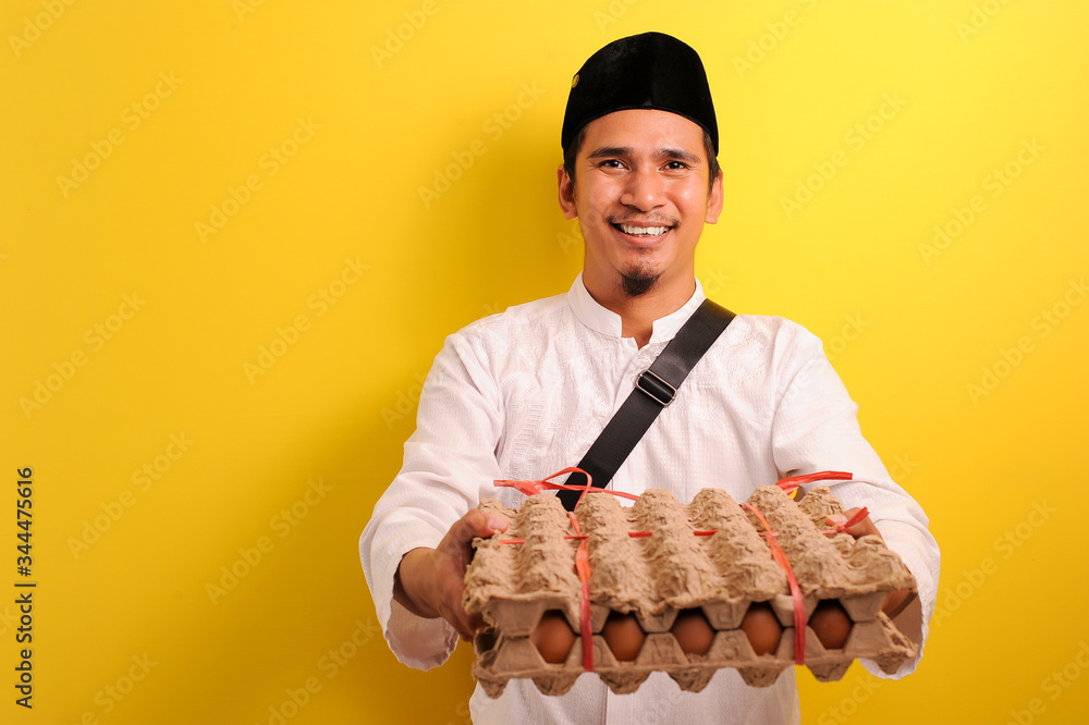 In Ramadan Kareem, Smiling Happy Young Asian Muslim man bring a plate of eggs to give for everyone need In Ramadan Kareem, Smiling Happy Young Asian Muslim man bring a plate of eggs to give for everyone need