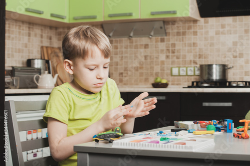 An Outbreak Of Coronavirus. Suspension and closure of kindergartens. The boy studies at home. The COVID-19 pandemic forces children to spend all their time at home.