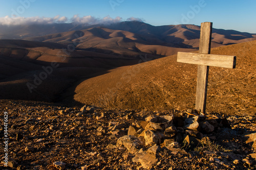 wooden cross and stone grave in the mountains
