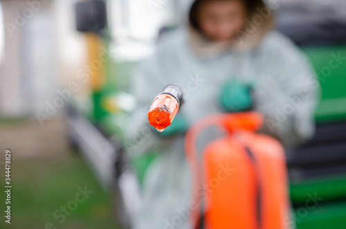 specialist wearing protective suit spray disinfectant chemicals on the cargo container or truck to prevent the spreading of the coronavirus.
logistics and freight concept
 during a pandemic