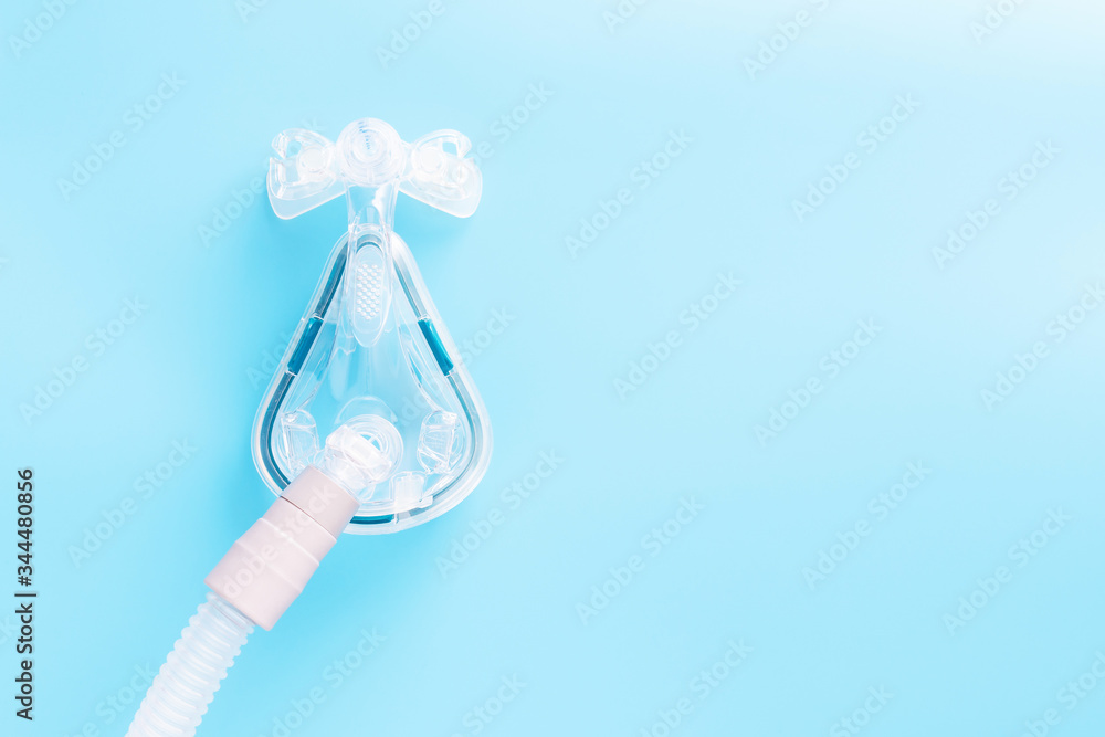 CPAP mask on blue background with copy space. Sleep apnea treatment concept. CPAP mask on blue background with copy space. Sleep apnea treatment concept.