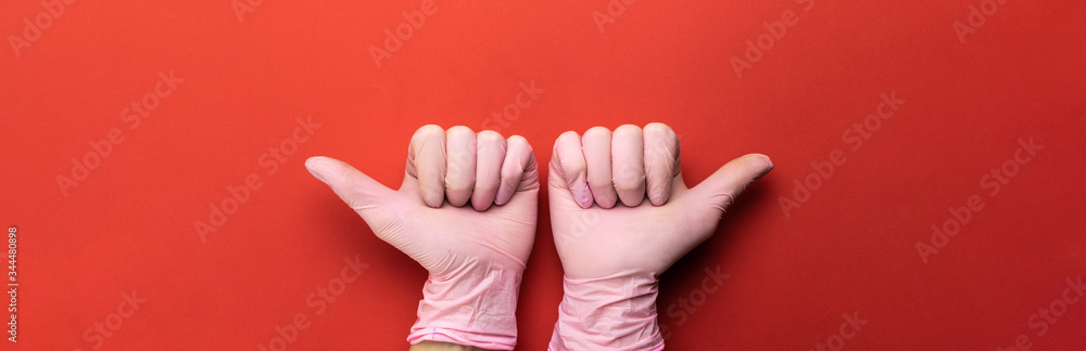 Medical examination glove. Using sanitizer lab gloves on red background. Cleansing hand hygiene for coronavirus outbreak prevention. Professional safety and hygiene for surgery and medical exam. Medical examination glove. Using sanitizer lab gloves on red background. Cleansing hand hygiene for coronavirus outbreak prevention. Professional safety and hygiene for surgery and medical exam.