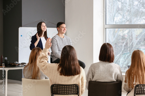 Professional hairdresser teaching young people in office