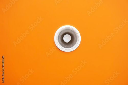 White lamp on the top of roof orange background.         