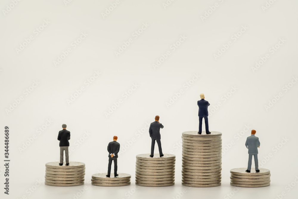Business man miniature people figure stand on top of stack of silver coin on white background with copy space using as saving, business, and financial concept. Business man miniature people figure stand on top of stack of silver coin on white background with copy space using as saving, business, and financial concept.