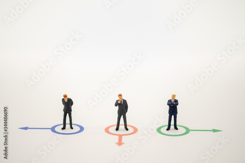 Businessman miniature people figure thinking in circle direction forward on white background with copy space using for business marketing and financial concept.
