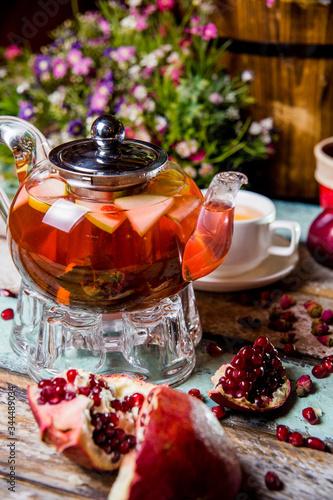 fruit red tea with pomegranate in a glass teapot