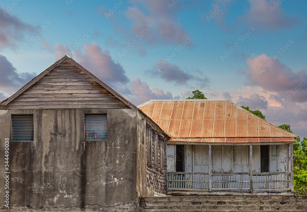 An old abandoned cement building with a rusty tin roof An old abandoned cement building with a rusty tin roof