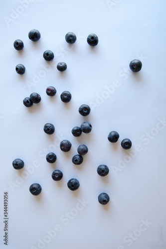 Blueberries scattered on the table. White background. Natural light. Top view 
