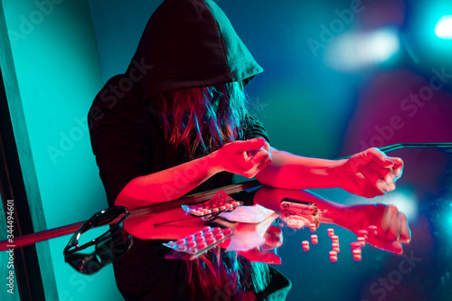 full background drug addict plans to inject heroin through a syringe into her veins on a mirrored table. Drug abuse concept