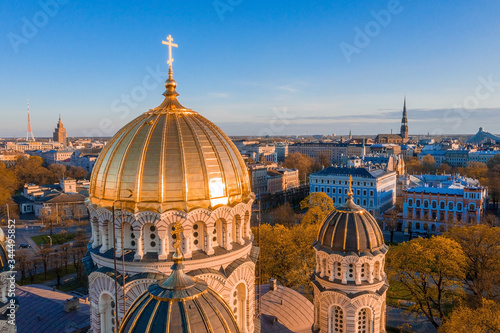 Aerial top view of Riga Nativity of Christ Cathedral - Famous Church And Landmark of Latvia. Golden Yellow Domes at sunset.  photo