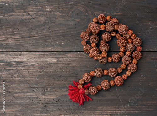Rudraksha prayer beads for meditation on a brown wooden background, top view photo