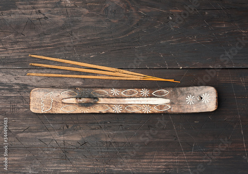 stack of incense sticks for rituals and a stand on a brown wooden table photo