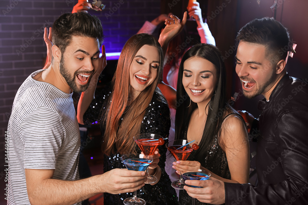 Fototapeta premium Happy young people with cocktails in night club