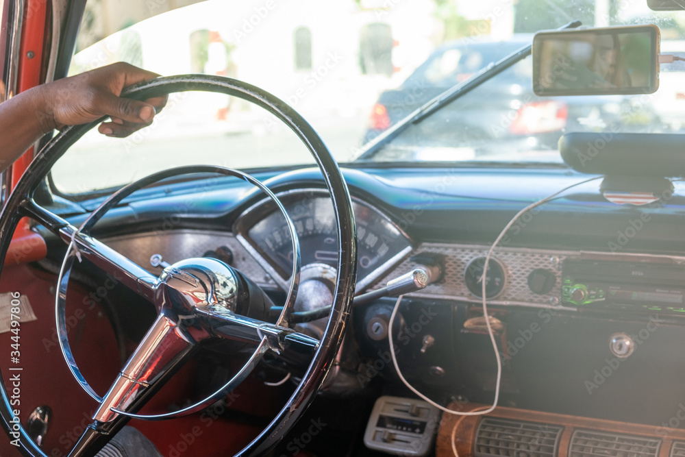 Obraz premium Close Up Shot Of Hand Of A Man Holding The Metal Steering Wheel Of Vintage Car On The Traffic Road.