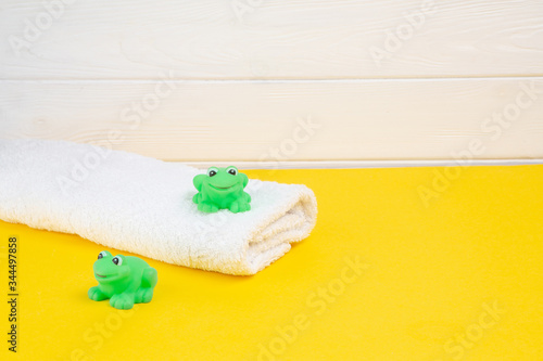 Spa and bath concept. Baby bath set and rubber frog on yellow background. photo