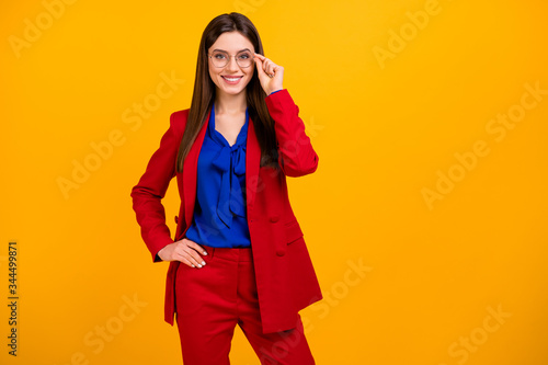 Photo of attractive self-confident business lady hold arm side toothy smiling standing bossy wear specs red luxury office blazer trousers suit isolated yellow bright color background