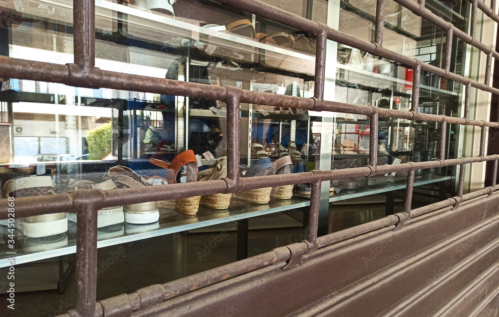 Rolling shutter closed on the shop window of a shoe shop locked for quarantine 2020 Rolling shutter closed on the shop window of a shoe shop locked for quarantine 2020