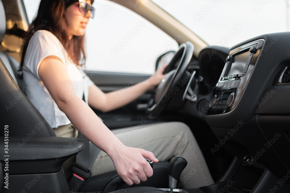 Woman use a hand brake system closeup. Parking brake inactivate Woman use a hand brake system closeup. Parking brake inactivate