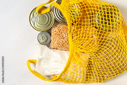 canned food and cereals in bundles in a yellow bag grid on a white background