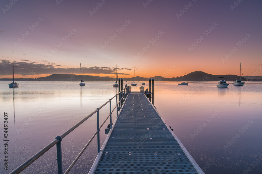 Obraz premium Along the Wharf Boats and a Sunrise Waterscape
