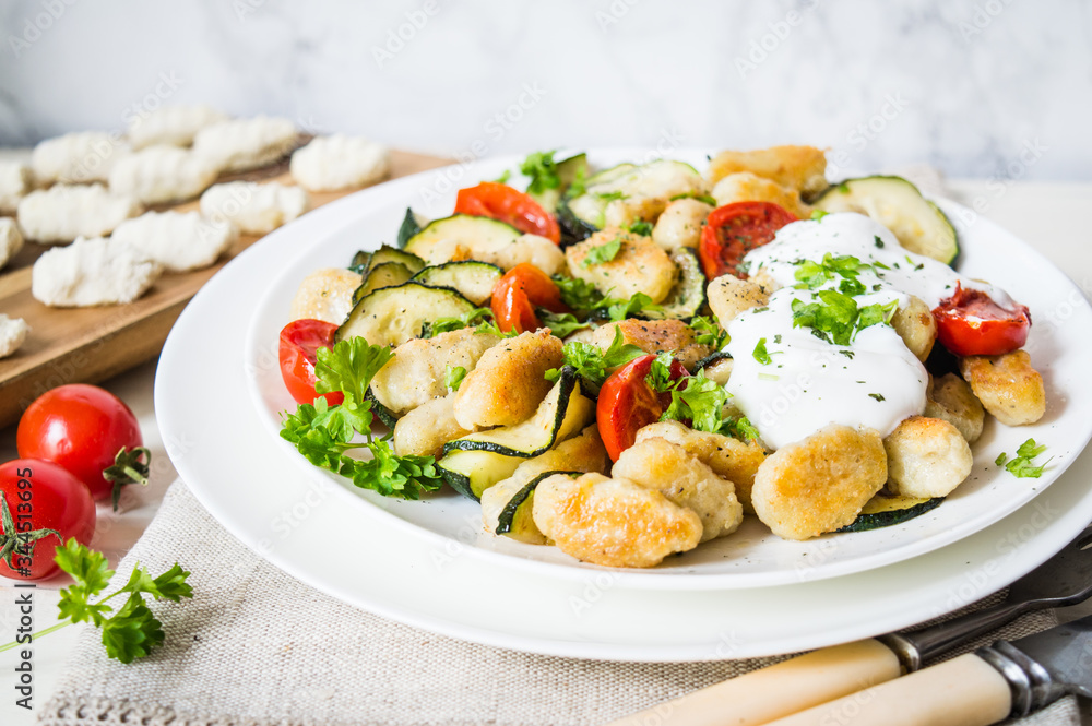 gnocchi with zucchini and cherry tomatoes on a plate gnocchi with zucchini and cherry tomatoes on a plate