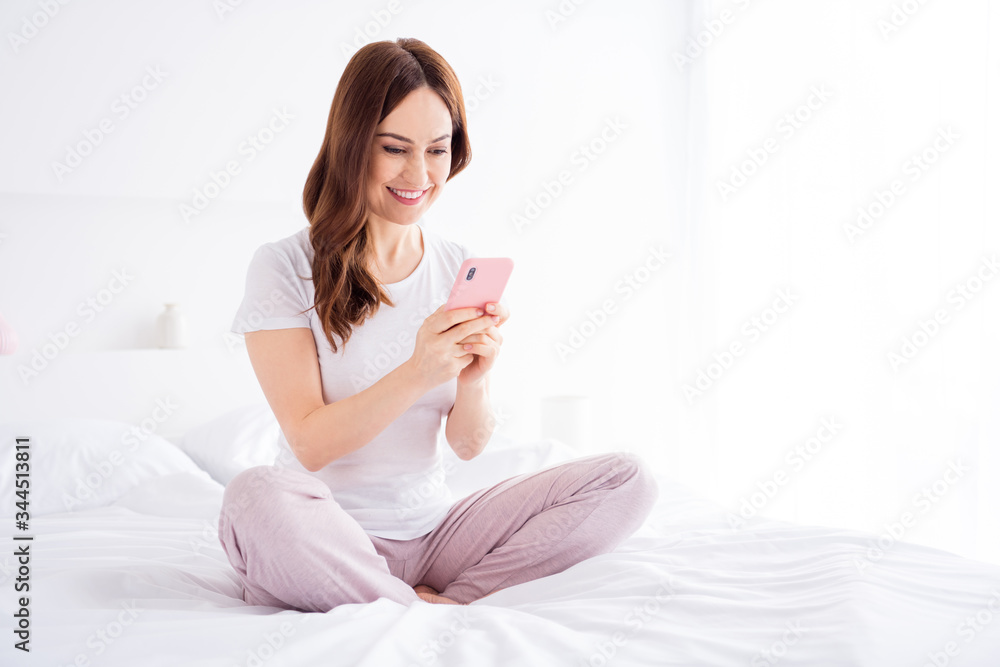 Portrait of her she nice attractive lovely pretty focused cheerful red haired girl sitting in bed using 5g app device in modern white light interior style room house apartment Portrait of her she nice attractive lovely pretty focused cheerful red haired girl sitting in bed using 5g app device in modern white light interior style room house apartment
