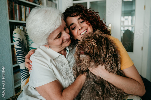 .Adorable portrait of a mother and daughter accompanied by their dog while at home during the covid quarantine19. Pet affection and company. selective focus photo