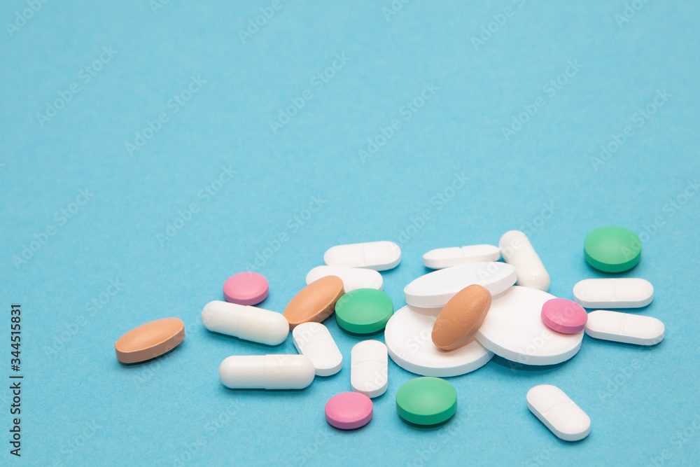 Assorted pharmaceutical medicine pills, tablets and capsules over blue background. Vitamins Tablets And Pharmaceuticals.Health and medical background. Assorted pharmaceutical medicine pills, tablets and capsules over blue background. Vitamins Tablets And Pharmaceuticals.Health and medical background.