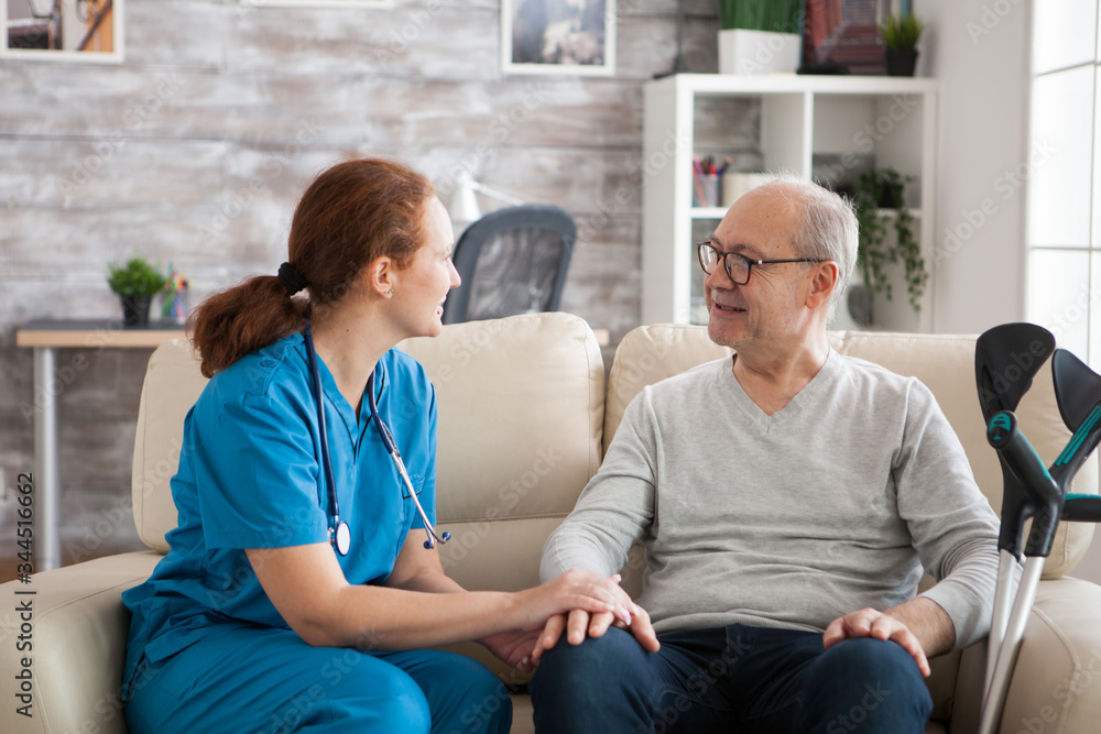Fototapeta premium Female doctor with stethoscope in nursing home talking with old patient.