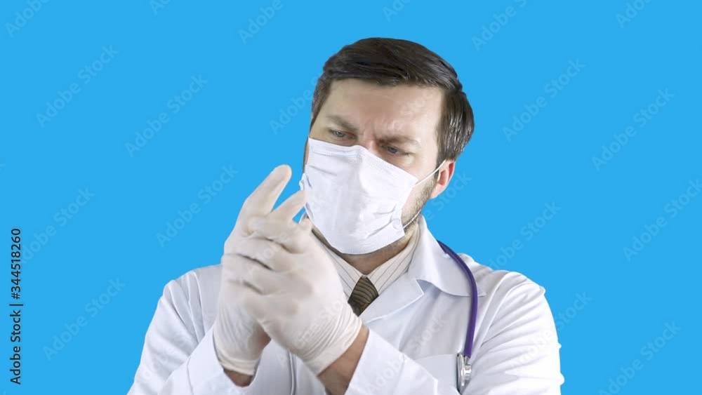 A medical worker puts gloves on his hands. A medical worker puts gloves on his hands.