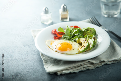 Fried egg with avocado and green salad