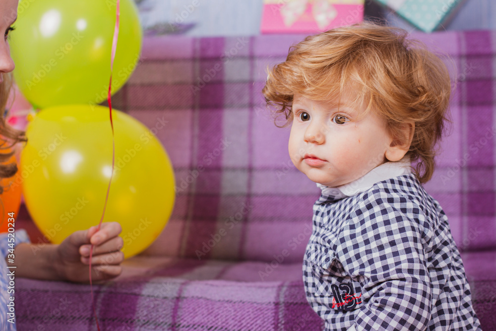 A child is celebrating his birthday. Portrait of a little boy with colorful balloons. Retro photo. A child is celebrating his birthday. Portrait of a little boy with colorful balloons. Retro photo.