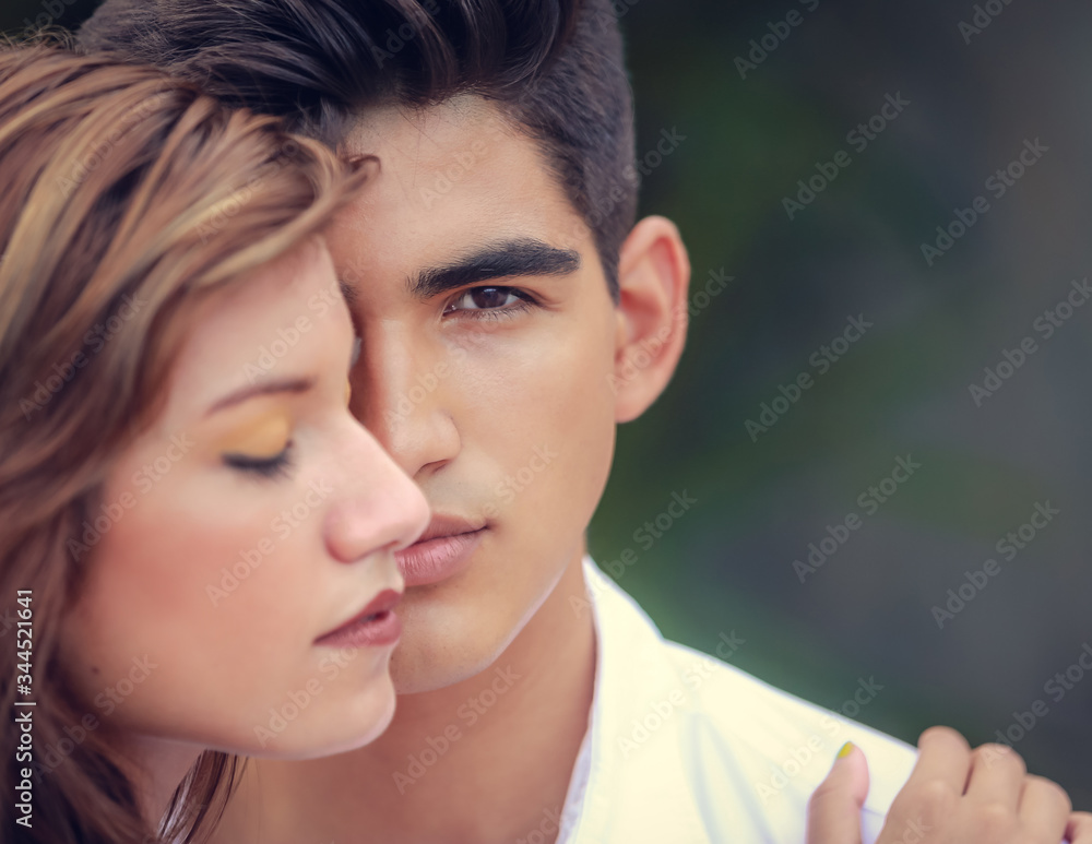 Beautiful sensual portrait of young couple in love. Portrait of hispanic couple outside. Man looking at camera, woman looking away Beautiful sensual portrait of young couple in love. Portrait of hispanic couple outside. Man looking at camera, woman looking away