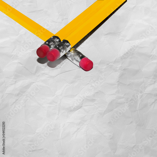 Long Pencils With Eraser on crumpled paper with texture with copy space. Stock Image.