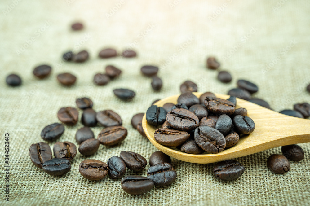 Roasted coffee beans in a wooden spoon.
