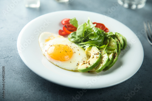 Fried egg with avocado and green salad
