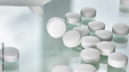 Few circle tablet antibiotic medical supplement falling on white. Shot on RED Raven hospital Cinema Camera